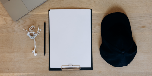 folha em branco, caneta e boné sobre a mesa