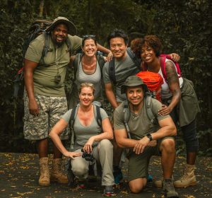 Grupo de pessoas etnicamente diversas acampando, exemplo de atividade de recreação, nicho do mercado de trabalho para educação física